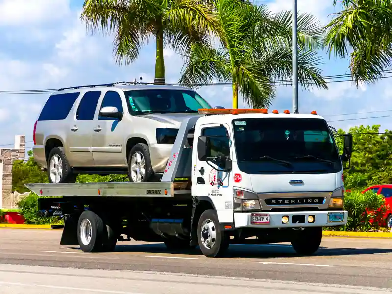 SUV being towed on a flatbed tow truck.