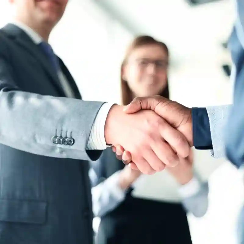 People in suits shaking hands.